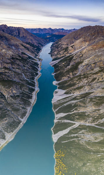 Blue lake of Livigno set between canyons and mountain ridges, aerial view, Sondrio province, Valtellina, Lombardy, Italy