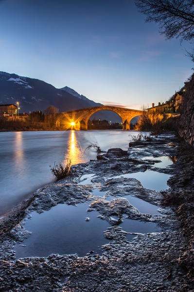 The lights of the Ganda Bridge reflecting in the River Adda by Morbegno at the blue hour - Valtellina, Italy