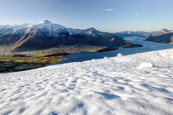 The snow sparkles lighted by the first sun rays of the day on the mounts of Montemezzo. Lombardy, Italy Europe