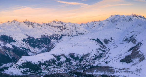 Aerial view of sunset on the snowy peaks surrounding Madesimo and Andossi, Valchiavenna, Valtellina, Lombardy, Italy