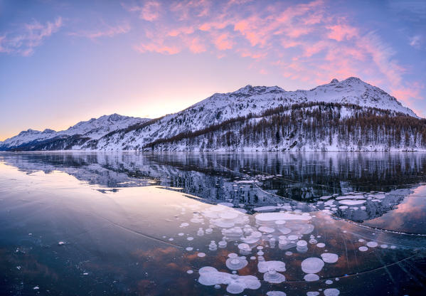 Sunrise on ice bubbles trapped in Lake Sils with Piz Da La Margna in background, canton of Graubunden, Engadine, Switzerland