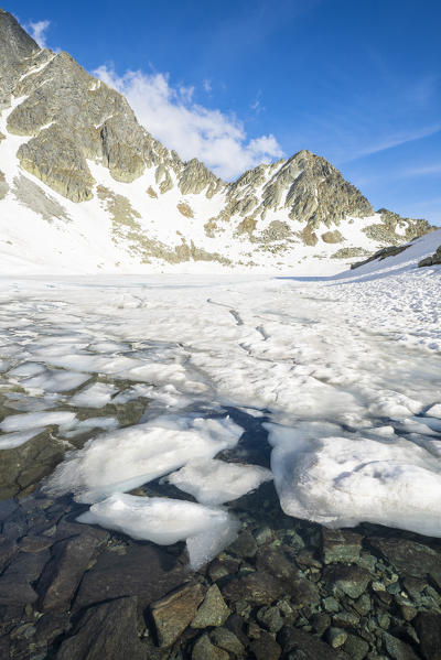 Melting snow on surface of Lago nero during thaw, Valchiavenna, Valle Spluga, Valtellina, Sondrio province, Lombardy, Italy