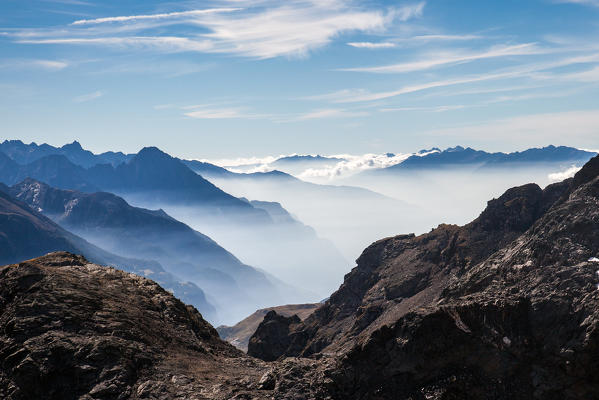 Fogs highlighting the silhouette of the peaks of Vallespluga, Valchiavenna, Valtellina Lombardy Italy Europe