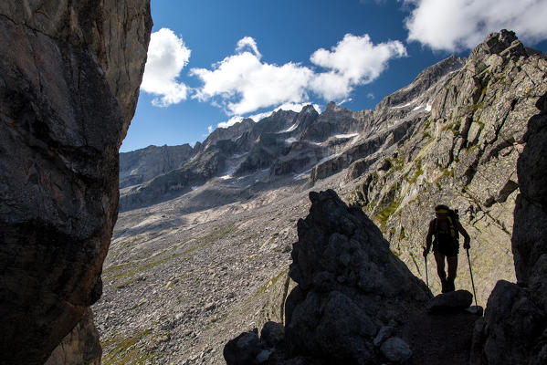 Hiker walking through Sentiero Roma at Qualido Pass, Valmasino.Valtellina Lombardy Italy Europe
