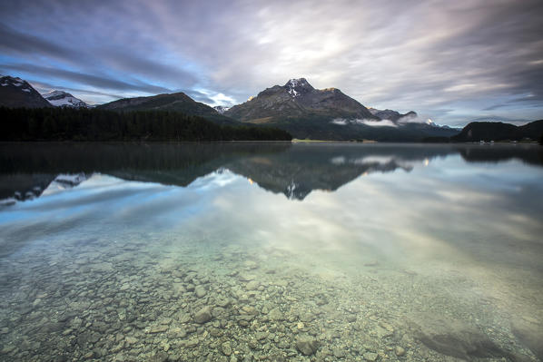 Dawn at lake Sils with clouds reflected in water.
Engadine Canton of Graubunden Switzerland Europe