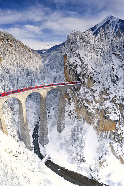 Bernina Express train on Landwasser viaduct during the snowy winter, Filisur, canton of Graubunden, Switzerland