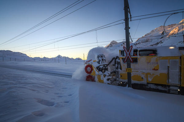 A machine cleaning the rails of the raethian railway at dawn. Bernina pass, Engadine, Canton of Grisons, Switzerland Europe