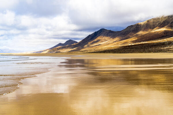 Golden sand of Cofete Beach surrounded by  mountains, Jandia natural park, Fuerteventura, Canary Islands, Spain