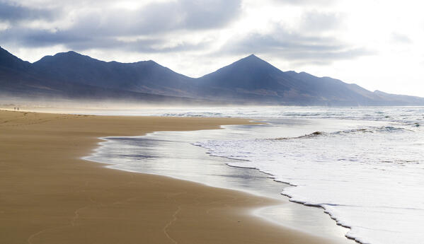 Waves crashing on Cofete Beach with mountains on background, Jandia peninsula, Fuerteventura, Canary Islands, Spain