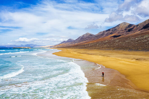 Lone fisherman on Cofete Beach washed by ocean waves, Jandia Nature Park, Fuerteventura, Canary Islands, Spain