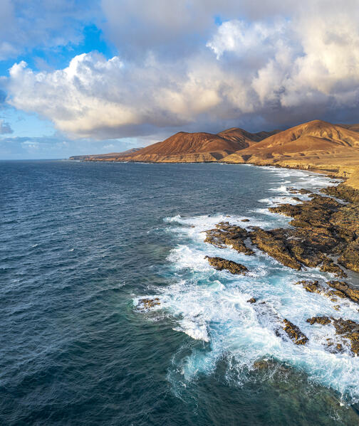 Clouds at sunset on breaking waves at Playa de la Solapa beach, aerial view, Pajara, Fuerteventura, Canary Islands, Spain