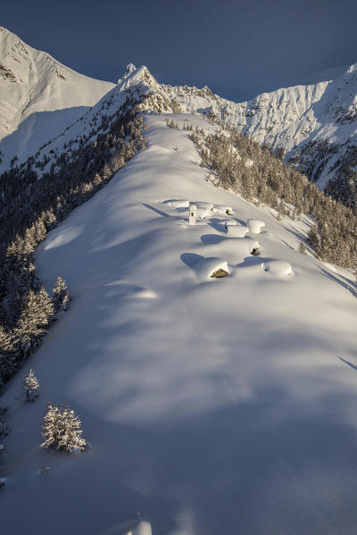 Aerial view of Alpe Scima isolated in the snow. Alpe Scima, Valchiavenna, Valtellina Lombardy Italy Europe