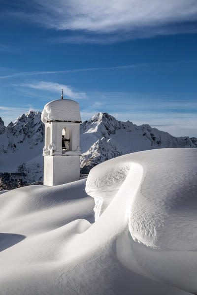 The snow covers in a cold hug the bell tower of the Alpe Scima. Alpe Scima, Valchiavenna, Valtellina Lombardy Italy Europe