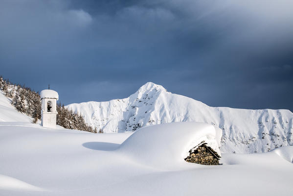 Wonderful contrast created by the white of snow and black of the clouds at Alpe Scima.  Valchiavenna, Valtellina Lombardy Italy Europe