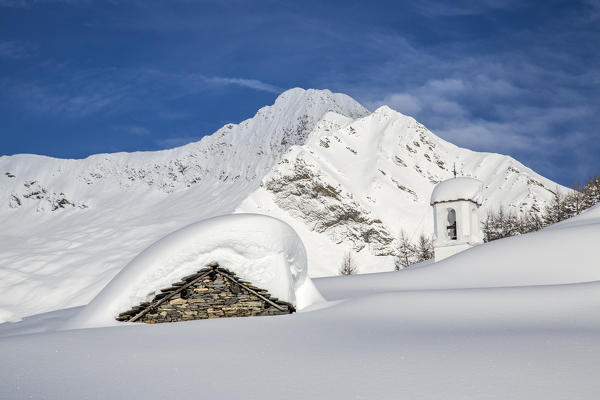 The huts and the bell tower of Alpe Scima sorrounded by metres of snow. Alpe Scima, Valchiavenna, Valtellina Lombardy, Italy Europe