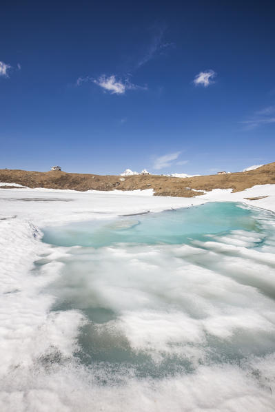 The ice begins to melt at Lake Hemet at thaw. Madesimo. CHiavenna Valley. Spluga Valley. Valtellina. Lombardy. Italy. Europe