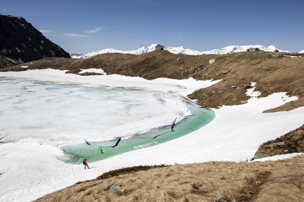 Photographer intent to capture lake Emet in thaw. Madesimo. CHiavenna Valley. Spluga Valley. Valtellina. Lombardy. Italy. Europe