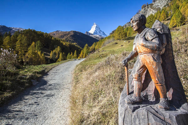 Wooden statue depicting a hiker on the path towards the Matterhorn Zermatt canton of Valais Switzerland Europe