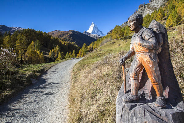 Wooden statue depicting a hiker on the path towards the Matterhorn Zermatt canton of Valais Switzerland Europe