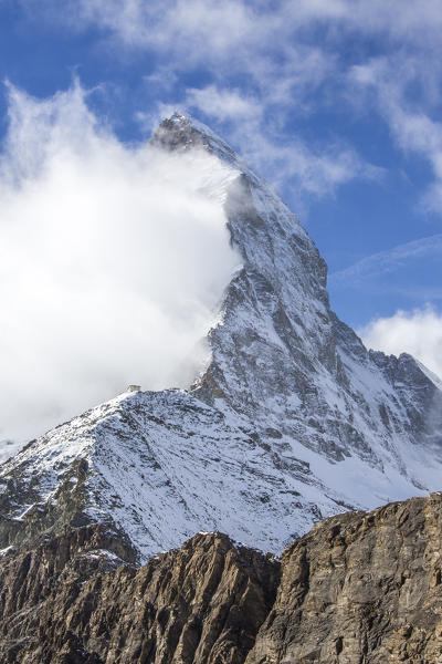 The peak of the Matterhorn covered in fog from the track to Hornli-hutte. Zermatt, Valais, Switzerland Europe