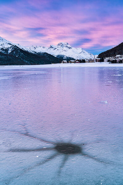 Pink sunrise over majestic Piz Da La Margna peak covered with snow and frozen lake Champfer, Graubunden, Engadine, Switzerland
