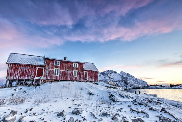 The colors of dawn light up the sky above Henningsvaer. Lofoten Islands. Norway. Europe 