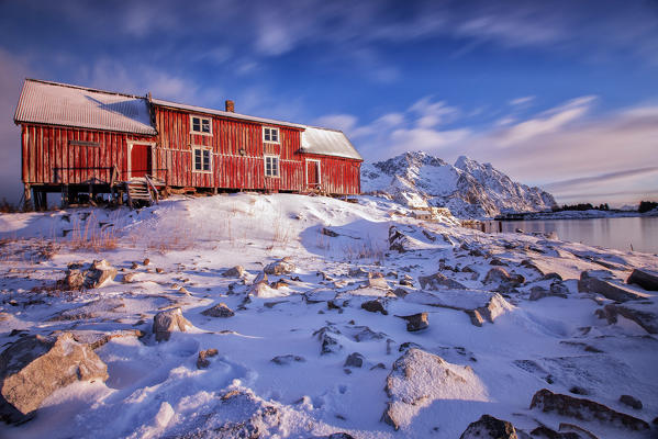 Clouds run over a typical red house of Henningsvaer. Lofoten Islands. Norway. Europe 