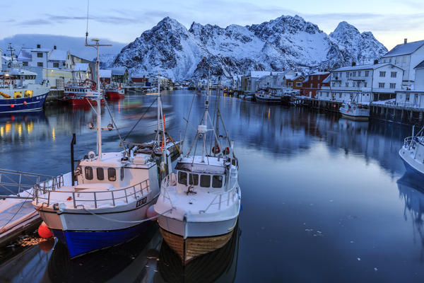 Boats in transit and boats moored in the port of Henningsvaer. Lofoten Islands. Norway. Europe