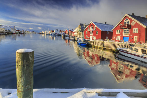 View from the pier on the channel Henningsvaer overlooked by the fishermens houses. Lofoten Islands. Norway. Europe