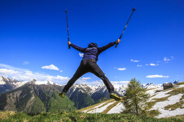 Hiker performs spectacular stunts on the slopes of Rosetta peak. Rasura. Valgerola. Valtellina. Lombardy. Italy. Europe