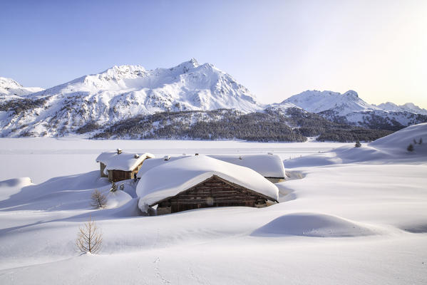 Meters of powder snow submerge the Spluga huts near Maloja Pass. Engadine. Switzerland. Europe