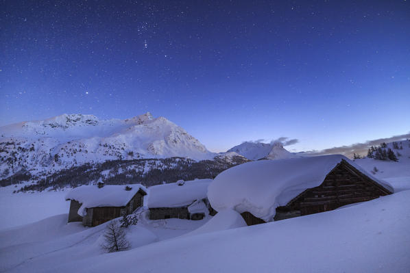 The Spluga huts surrounded by meters of snow during a starry night. Maloja Pass. Engadine. Switzerland. Europe