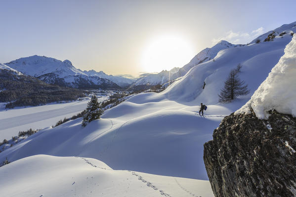 Solitary hiker on snowshoes adventure in deep snow after a heavy snowfall at the Maloja Pass. Canton of Graubunden. Engadine. Switzerland. Europe