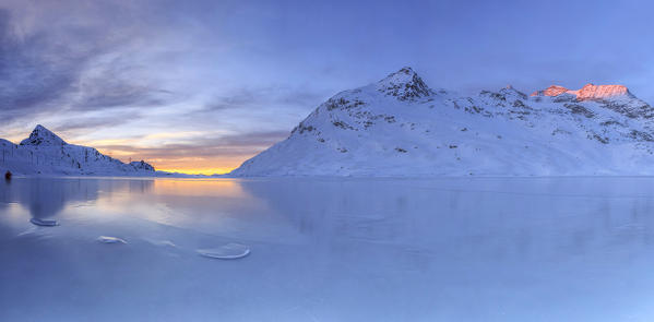 Overview from the frozen surface of Lake Bianco at the Bernina Pass at sunrise. Canton of Graubunden. Engadine. Switzerland. Europe