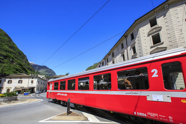 Transit of the Red Train heritage of Unesco in the center of Tirano at the entrance of Poschiavo Valley. Valtellina. Lombardy. Italy. Europe