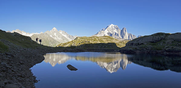 Hikers admire the view of Mont Blanc range from Lac de Chesery. Haute Savoie. France Europe