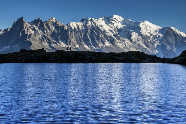 Hikers admire the view of Mont Blanc range from Lac de Chesery. Haute Savoie. France