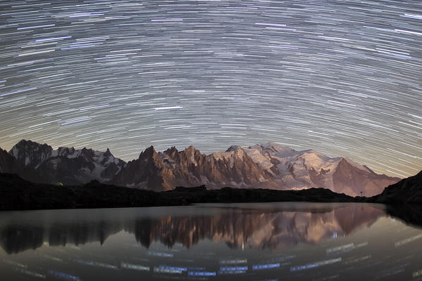 Star trail over Mont Blanc range seen from Lac de Chesery. Chamonix. Haute Savoie France
