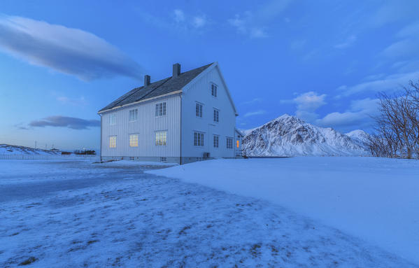 Typical house surrounded by snow at dusk. Flakstad Lofoten Islands Norway Europe