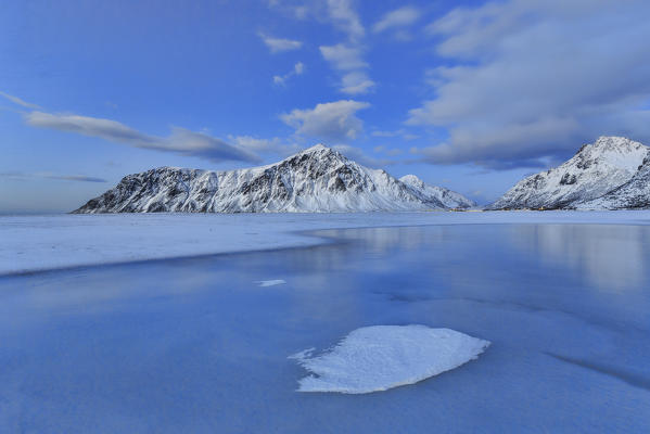 Blue of dusk dominates the scenery in Flakstad with its cold sea and the snowy peaks. Lofoten Islands Northern Norway Europe