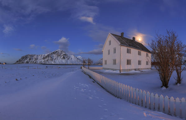 Typical house surrounded by snow in a cold winter day at dusk. Flakstad Lofoten Islands Norway Europe