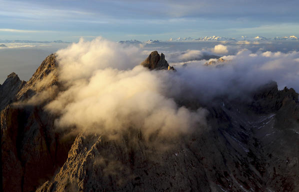 Aerial view of the mountain range of Odle surrounded by clouds. Dolomites Val Funes Trentino Alto Adige South Tyrol Italy Europe