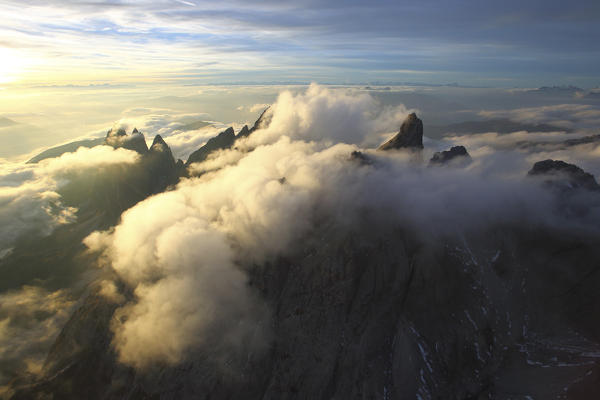 Aerial view of the mountain range of Odle surrounded by clouds. Dolomites Val Funes Trentino Alto Adige South Tyrol Italy Europe