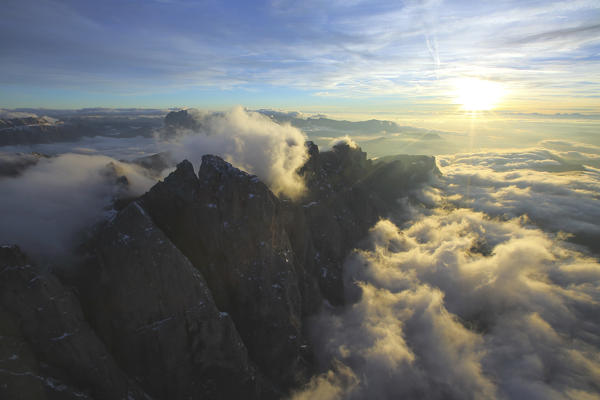 Rays of setting sun light up the summits hidden by clouds. Odle Val Funes Dolomites Trentino Alto Adige South Tyrol Italy Europe