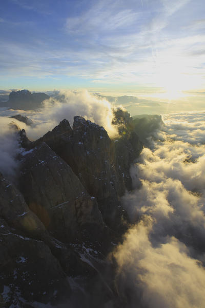 Rays of setting sun light up the summits hidden by clouds. Odle Val Funes Dolomites Trentino Alto Adige South Tyrol Italy Europe