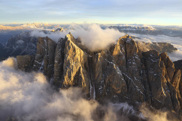 Aerial view of the mountain range of Odle surrounded by clouds. Dolomites Val Funes Trentino Alto Adige South Tyrol Italy Europe