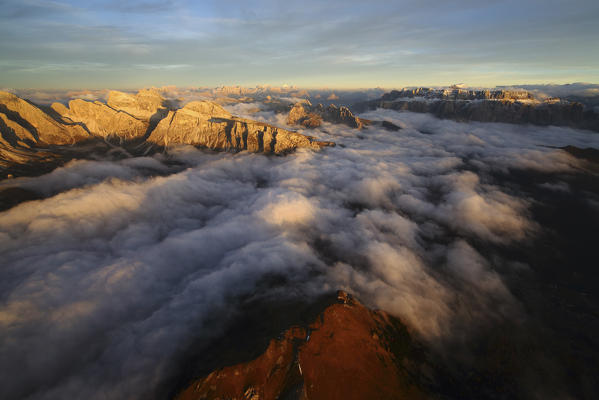 Aerial shot of  Sella Group Alps surrounded by clouds at sunset. Dolomites Trentino Alto Adige. Italy Europe