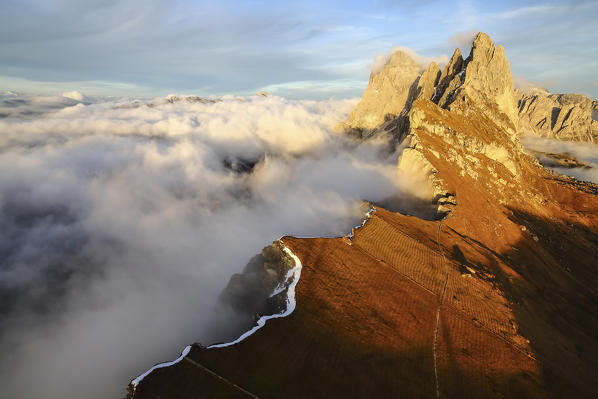 Aerial shot from Seceda of Odle surrounded by clouds at sunset. Dolomites Funes Valley Trentino Alto Adige South Tyrol Italy Europe