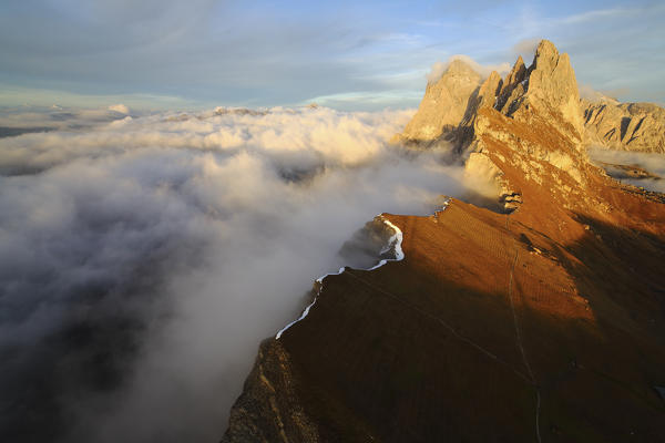 Aerial shot from Seceda of Odle surrounded by clouds at sunset. Dolomites Val Funes Trentino Alto Adige South Tyrol Italy Europe