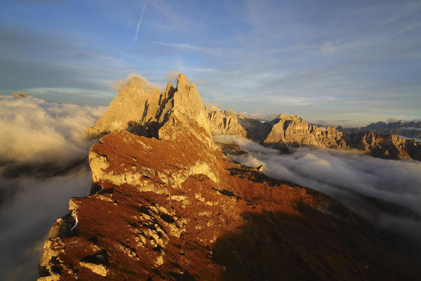 Aerial shot from Seceda of Odle surrounded by clouds at sunset. Dolomites Val Funes Trentino Alto Adige South Tyrol Italy Europe